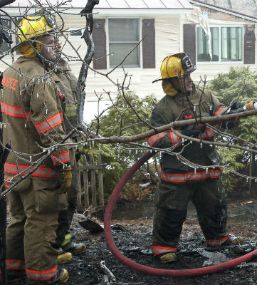 Firefighters with frozen tree limb