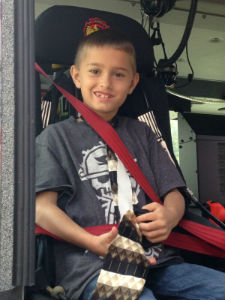little boy in a firetruck