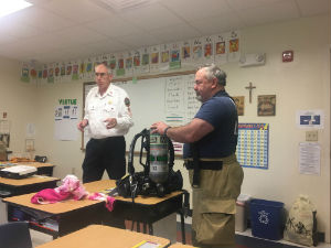 Firemen showing kids their clothes
