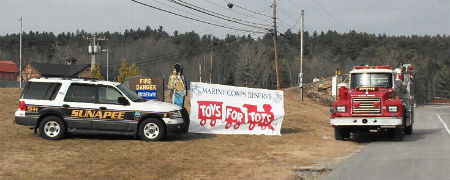 fire truck and police car with toys for tots banner