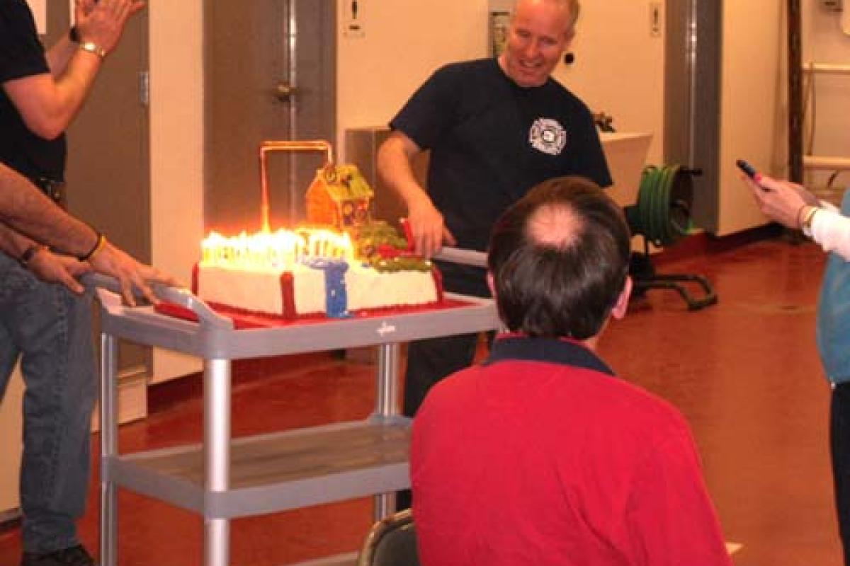 Man with fire extinguisher next to a cake