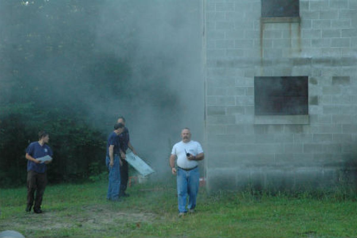 Firemen next to a burning building